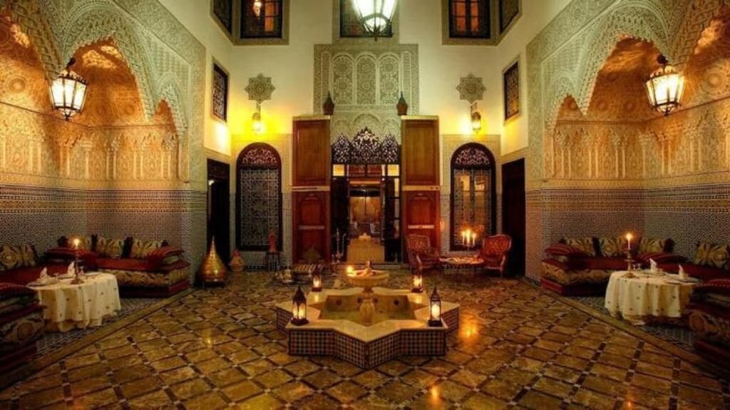 Un interno decorato con piastrelle elaborate, una fontana al centro e zone relax.