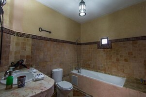 Un baño con lavamanos, inodoro y bañera.