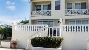A multi-story building with balconies, a staircase, and a potted plant. - Unit 6 Coast Luxury Town Homes  Newly Refurbished (Rodney Bay)