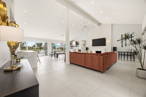 Ein modernes Wohnzimmer mit einer Couch, einem Essbereich und einer Küche.
