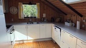 Een koffiezetapparaat/waterkoker, een koelkast, een oven, een vaatwasser