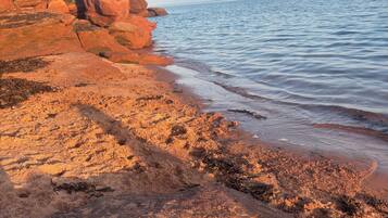 A coastal landscape with rocky terrain and a calm sea.