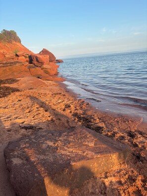 A coastal landscape with rocky terrain and a calm sea. - South shore time capsule (Canoe Cove)