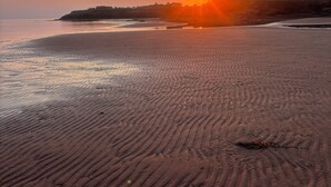 A beach with a sunset, sandy terrain, and a distant shoreline. - South shore time capsule (Canoe Cove)