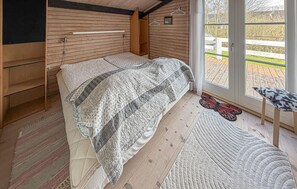 A wooden interior with a bed, a bench, and a view through a glass door. - Nice home in Broager with WiFi (Broager)
