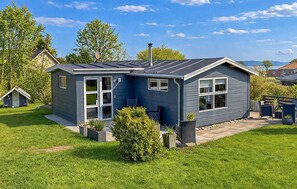 A single-story house with a dark blue exterior, a front porch, and a small garden area. - Nice home in Broager with WiFi (Broager)