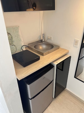 A compact kitchen with a sink, a small refrigerator, and a wooden countertop. - Beach side Ocean Park tropical studio.     High-Speed WiFi (San Juan)