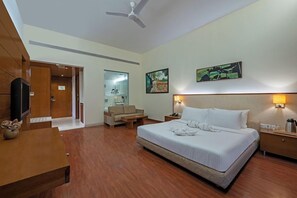 Une chambre d’hôtel équipée d’un lit, d’une table de chevet, d’une lampe et d’un téléviseur.