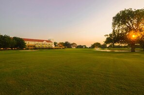 Un campo da golf con un edificio sullo sfondo.