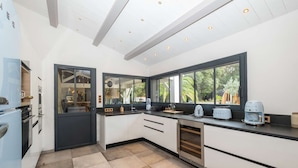 Een moderne keuken met een groot raam, inbouwapparatuur en een strak design.