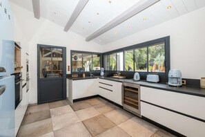 Eine moderne Küche mit großem Fenster, eingebauten Geräten und einem eleganten Design.