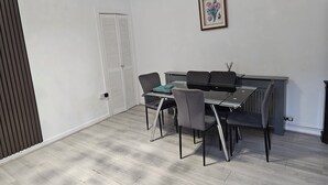 Una habitación con una mesa de comedor, sillas, un radiador y una puerta.