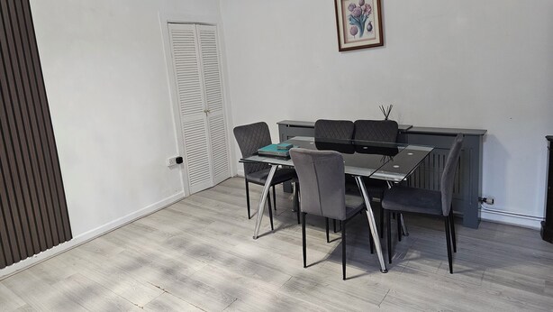 A room with a dining table, chairs, a radiator, and a door. - M4 Victoria Hub 1 (Newport)