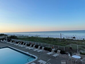 A pool area with lounge chairs and a view of the beach. - Beach side with a great view - 3-bedroom condo on Panama City Beach (Panama City Beach)