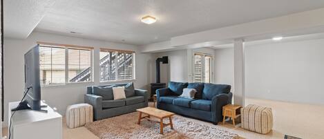 Ein Wohnzimmer mit zwei Sofas, einem Couchtisch, einem Fernseher und einem Kamin.