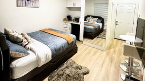 A bedroom with a bed, a desk, a chair, a mirror, and a door. - Quiet Private Room Victoria - PS5, Fast WiFi, Parking (Langford)