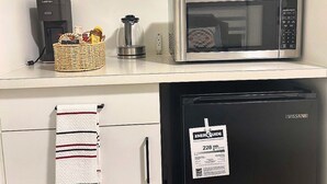 A kitchenette with a microwave, a coffee maker, a refrigerator, and a basket of items on the counter. - Quiet Private Room Victoria - PS5, Fast WiFi, Parking (Langford)