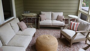 A cozy room with a sofa, armchair, ottoman, and a small table.