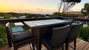 A wooden deck with a table and chairs, overlooking a landscape with trees and a distant horizon. - Treetop Ocean Views at Maslin Beach Coastal Escape (Maslin Beach)