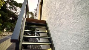 A modern staircase with metal railings leading to a building with a textured exterior wall. - Treetop Ocean Views at Maslin Beach Coastal Escape (Maslin Beach)