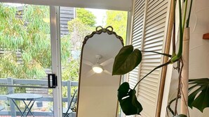 A room with a bed, a large mirror, and a potted plant. - Treetop Ocean Views at Maslin Beach Coastal Escape (Maslin Beach)