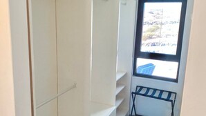 A narrow hallway with a closet, a window, and a rack. - The View Hotel CV (Sao Filipe)