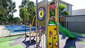 A playground with a slide, climbing structures, and a pool. - Collie Ridge Motel (Collie)