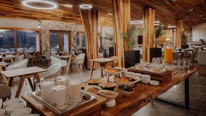 Un restaurant avec un plafond en bois, des murs en pierre et un buffet proposant une variété de plats.