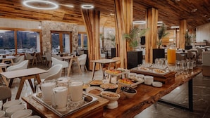 Un restaurante con techo de madera, paredes de piedra y un bufé con diferentes opciones de comida.