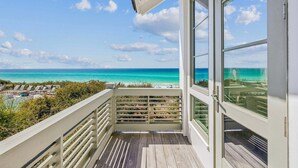 En balkon med udsigt over havet og stranden.