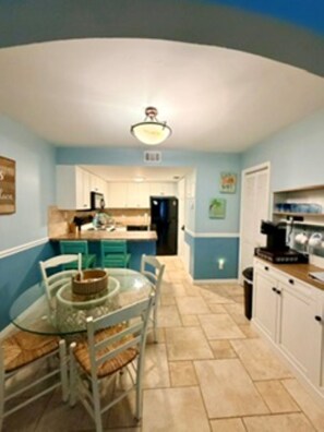 A kitchen with a dining table, chairs, and cabinets. - Amazing First Floor Condo steps from the Beach w/ breathtaking views - sleeps 6 (Cape Canaveral)