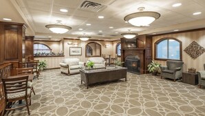 A spacious living area with a fireplace, multiple seating options, and a patterned carpet. - Holiday Inn Oxford (Oxford)