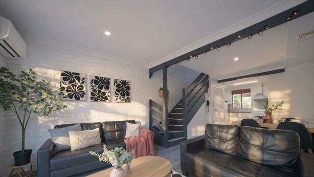 Een moderne woonkamer met een bank, salontafel en decoratieve wandkunst.