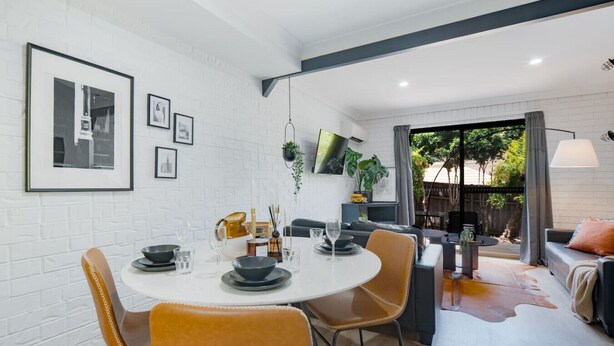 Un comedor moderno con una mesa redonda, sillas y vistas al exterior.
