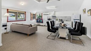Una cocina moderna con comedor, sofá y ventilador de techo.