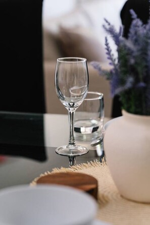 A clear glass wine glass on a table with a blurred background. - Value 3 Beds Family Stay w/ Pool, Near Bay & Shops (Wynnum)