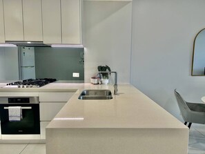 Eine moderne Küche mit einer zentralen Kochinsel, Edelstahlgeräten und einem minimalistischen Design.