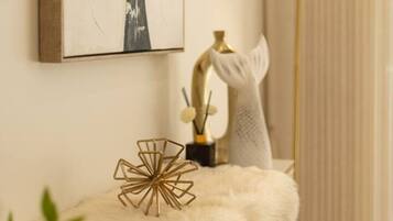 A room with a white cabinet, a gold lamp, and a framed abstract painting on the wall.