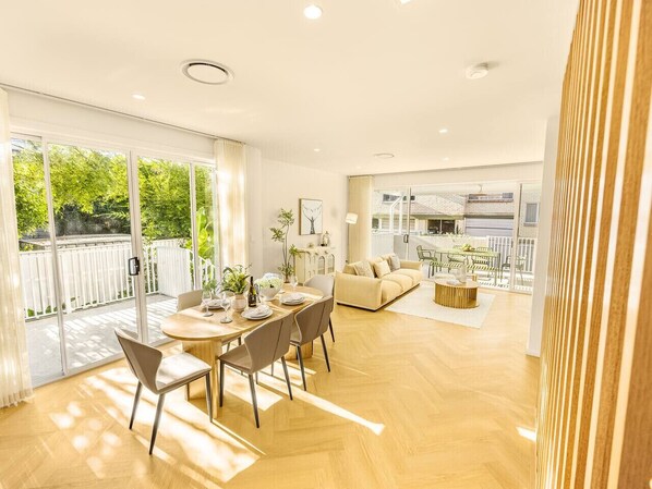 A spacious living area with a dining table, chairs, and a sofa.