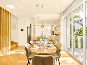 A modern dining area with a round table set for four, surrounded by chairs.