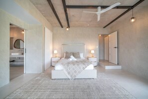 A modern bedroom with a large bed, bedside tables, and a ceiling fan. - Luxury 6BR Hinterland Retreat w/ Pool &Scenic View (Bonogin)
