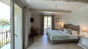 Une chambre à coucher avec un lit, une table de chevet, une lampe et un téléviseur fixé au mur.