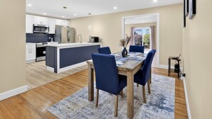A modern kitchen with white cabinets, stainless steel appliances, and a central island. - Perfect 4-bedroom house with AC in tranquil Albany (Albany)