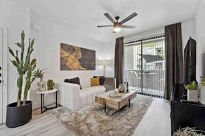 A modern living room with a sofa, coffee table, and a ceiling fan. - Stylish 1-bedroom with Resort Amenities located in Glendale (Glendale)