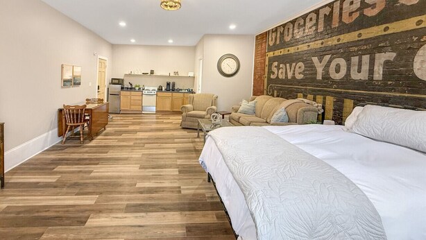 A spacious room with a large bed, a kitchen area, and a dining table. - Historic Harmar Studio | Walk to Dining (494751) (Marietta)