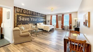 A spacious living area with a sofa, a dining table, and a bed. - Historic Harmar Studio | Walk to Dining (494751) (Marietta)