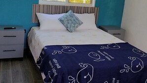 Una camera da letto con un letto, una finestra, un comodino e una cassettiera.