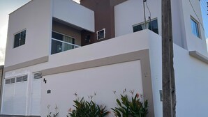 Un edificio moderno su due piani con tetto piatto, ampie finestre e un garage.