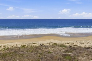 A beach with waves, a clear sky, and dry vegetation. - 1452  Ocean Front 2 bedroom (Bajos de Chila)