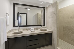 A bathroom with two vessel sinks, a large mirror, and a walk-in shower. - 1452  Ocean Front 2 bedroom (Bajos de Chila)